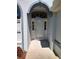Close up view of the white front door, framed by arched windows and surrounded by lush landscaping at 7407 Sw 112Th Pl, Ocala, FL 34476