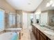 A spacious bathroom with double sinks, a soaking tub, and a glass-enclosed shower at 7527 Sw 97Th Terrace Rd, Ocala, FL 34481