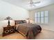 Bright bedroom with a wooden bed frame, a ceiling fan, and shuttered windows at 7527 Sw 97Th Terrace Rd, Ocala, FL 34481