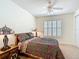 Bright bedroom with a ceiling fan, shuttered windows, and decorative lamps at 7527 Sw 97Th Terrace Rd, Ocala, FL 34481