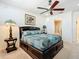 Bedroom with a ceiling fan, ensuite bathroom and a decorative lamp at 7527 Sw 97Th Terrace Rd, Ocala, FL 34481