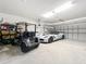 Spacious garage featuring a golf cart and a white Corvette at 7527 Sw 97Th Terrace Rd, Ocala, FL 34481