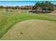 Aerial view of the community golf course featuring manicured greens and mature trees under a bright blue sky at 7527 Sw 97Th Terrace Rd, Ocala, FL 34481