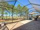 Screened lanai showcasing outdoor seating, a golf course view, and a partially shaded patio at 7527 Sw 97Th Terrace Rd, Ocala, FL 34481