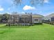 View of the backyard featuring a large lawn and manicured landscaping, with a screened-in pool area at 8033 Nw 28Th St, Ocala, FL 34482