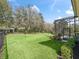 Expansive, well-manicured backyard with lush green grass and landscaped borders, leading to a screened-in pool area at 8033 Nw 28Th St, Ocala, FL 34482