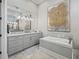Elegant bathroom with double vanity sinks, a soaking tub, and stylish light fixtures at 8033 Nw 28Th St, Ocala, FL 34482