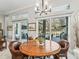 Elegant dining area with a round wooden table and views of the outdoor pool area at 8033 Nw 28Th St, Ocala, FL 34482