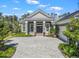 The home's inviting facade features a patterned driveway, lush landscaping, and double front doors at 8033 Nw 28Th St, Ocala, FL 34482