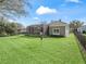 Rear view of the house highlighting the yard, screen enclosed patio, and outdoor pool at 8033 Nw 28Th St, Ocala, FL 34482