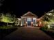 Well-lit home features landscape lighting, manicured garden, and welcoming front entrance at 8033 Nw 28Th St, Ocala, FL 34482