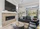 Inviting living room featuring a stone fireplace, large TV, and comfortable black leather seating at 8033 Nw 28Th St, Ocala, FL 34482