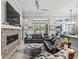 Inviting living space with a cozy stone fireplace, plush sofas, and a view of the outdoor living area at 8033 Nw 28Th St, Ocala, FL 34482