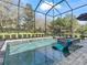 Screened pool with a built-in lounge chair and a fire pit feature, perfect for relaxation and entertainment at 8033 Nw 28Th St, Ocala, FL 34482