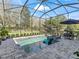 Screened pool featuring a built-in lounge chair, a fire pit, and beautiful landscaping around the pool area at 8033 Nw 28Th St, Ocala, FL 34482