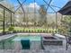 Inviting screened pool area with a tanning ledge and a fire pit, surrounded by lush landscaping at 8033 Nw 28Th St, Ocala, FL 34482