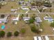 Overhead view of homes with pools, landscaped yards, and tree-lined streets in a peaceful community setting at 8106 County Road 109, Lady Lake, FL 32159
