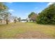 Expansive backyard featuring lush greenery, mature trees, and utility structures creating a peaceful and functional outdoor space at 8106 County Road 109, Lady Lake, FL 32159