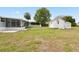 Large backyard featuring white storage shed, screened in porch, and fenced in yard at 8106 County Road 109, Lady Lake, FL 32159