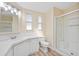 Well-lit bathroom with a walk-in shower, laminate flooring, and white vanity at 8106 County Road 109, Lady Lake, FL 32159