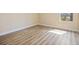 Cozy bedroom featuring wood-look flooring, natural light from the window, and baseboard trim at 8106 County Road 109, Lady Lake, FL 32159