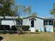 Charming single-story home with light blue siding and a well-manicured front yard at 8106 County Road 109, Lady Lake, FL 32159