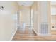 Bright hallway featuring wood-look flooring and neutral wall color connecting to multiple rooms at 8106 County Road 109, Lady Lake, FL 32159