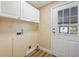 Dedicated laundry room with storage cabinets, washer hookups, and an exterior door to the backyard at 8106 County Road 109, Lady Lake, FL 32159