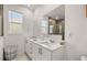 Bright bathroom featuring double sink vanity with quartz countertops, a large mirror, and natural light at 8802 Sw 79Th Loop, Ocala, FL 34481
