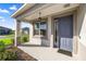 Inviting front porch with a stylish blue door, offering a glimpse of the neighborhood at 8802 Sw 79Th Loop, Ocala, FL 34481