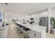 Modern, open-concept kitchen with a large island, stainless steel appliances, and sleek white cabinetry at 8802 Sw 79Th Loop, Ocala, FL 34481