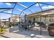 Covered lanai features an outdoor kitchen, dining area, and comfortable seating for relaxation at 8802 Sw 79Th Loop, Ocala, FL 34481