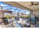 Covered screened patio with outdoor furniture, dining table, and ceiling fan at 8802 Sw 79Th Loop, Ocala, FL 34481