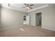 Bright main bedroom featuring carpet floors, a ceiling fan, and ensuite bathroom and walk-in closet access at 8899 Sw 50Th Ave, Ocala, FL 34476