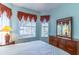 Comfortable bedroom equipped with a ceiling fan, large window and neutral color paint at 9458 Sw 93Rd Loop, Ocala, FL 34481