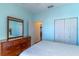 Comfortable bedroom featuring blue walls, dresser, and a closet for storage, creating a serene and organized living space at 9458 Sw 93Rd Loop, Ocala, FL 34481