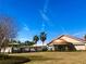 Beautiful clubhouse with palm trees, modern architecture, and a lush green lawn at 9458 Sw 93Rd Loop, Ocala, FL 34481