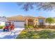 Beautiful single-Gathering home with an attached garage, manicured lawn, and a red golf cart parked in the driveway at 9458 Sw 93Rd Loop, Ocala, FL 34481