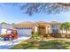 Charming home featuring a well-manicured lawn, two-car garage, and a red golf cart at 9458 Sw 93Rd Loop, Ocala, FL 34481