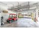 Spacious garage with storage racks, visible golf cart and open view of the front of the house at 9458 Sw 93Rd Loop, Ocala, FL 34481