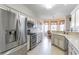 Modern kitchen boasts stainless steel appliances, white cabinets, granite countertops and light tile flooring at 9458 Sw 93Rd Loop, Ocala, FL 34481