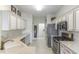 Bright kitchen offers stainless steel appliances, white cabinets, granite countertops and light tile flooring at 9458 Sw 93Rd Loop, Ocala, FL 34481