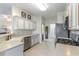 Well-lit kitchen features stainless steel appliances, white cabinets, granite countertops and light tile flooring at 9458 Sw 93Rd Loop, Ocala, FL 34481