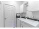 Bright laundry room featuring a washer, dryer, white cabinets, and a door at 9458 Sw 93Rd Loop, Ocala, FL 34481