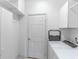 Clean, all-white laundry room with washer, dryer, cabinets and a door at 9458 Sw 93Rd Loop, Ocala, FL 34481