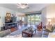 Cozy living room with ceiling fan, hardwood floors, and screened in patio doors at 9458 Sw 93Rd Loop, Ocala, FL 34481