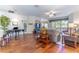 Spacious living area showcasing wood floors, a ceiling fan, and seamless transition to the dining area at 9458 Sw 93Rd Loop, Ocala, FL 34481