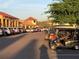 Parking lot with cars and golf carts in front of buildings, sunny sky at 9458 Sw 93Rd Loop, Ocala, FL 34481