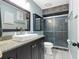 This is a renovated bathroom with a tiled walk-in shower, granite counters, and updated fixtures at 12453 Se 61St Ct, Belleview, FL 34420