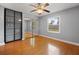 Empty bedroom with wood floors, light grey walls, a ceiling fan, and built-in mirrored wardrobes at 12453 Se 61St Ct, Belleview, FL 34420